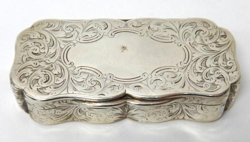 A Victorian silver shaped rectangular snuff box, the exterior with feathered scroll engraved decoration, maker Hilliard & Thomason, Birmingham 1851, w
