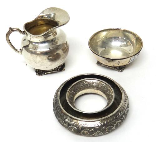 A Mexican silver milk jug, with a matching silver sugar bowl, each raised on four feet, detailed 925 Sterling Mexico, combined weight 371 gms and an E