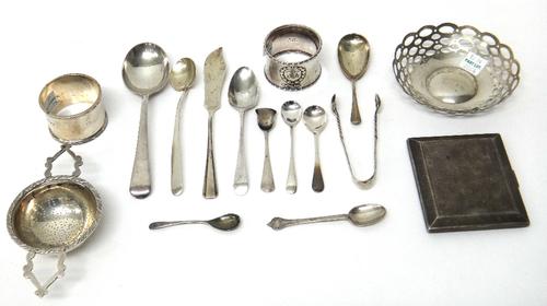 Silver, comprising; a shaped circular bonbon dish, with pierced decoration, a twin handled tea strainer, two napkin rings, a cigarette case, a butter