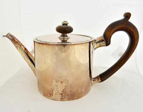 A George III silver teapot, of cylindrical form, with a pull-off lid and with a wooden handle, London probably 1771, gross weight 587 gms.  Illustrate