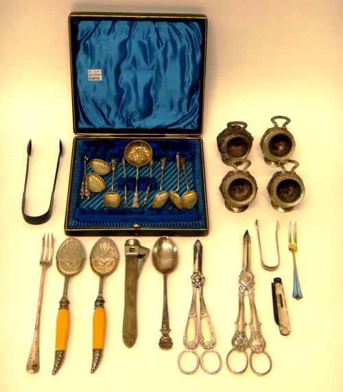 A set of four Eastern salts, formed as miniature coal scuttles, decorated with Deity figures, two pairs of plated grape scissors, a pair of plated pre