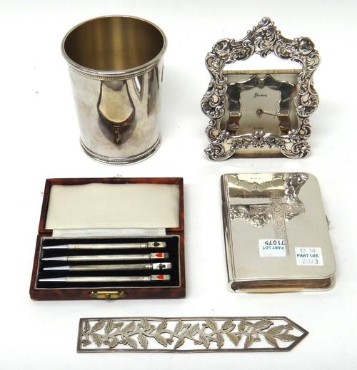 Sterling and Sterling mounted wares, comprising; a beaker of tapering cylindrical form, a Book of Common Prayer, a Gorham clock, the case front decora