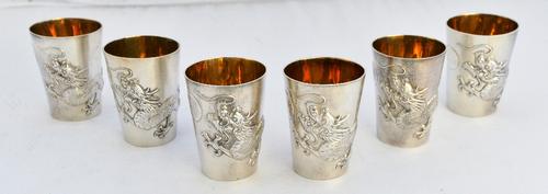 A set of six Oriental spirit cups, each decorated with a dragon, on a stippled ground, height 6cm, detailed Zeewoo, probably Chinese, with a fitted wo