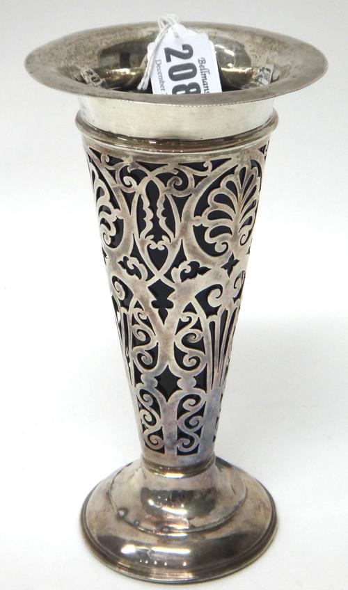 A silver vase, with scroll pierced decoration, on a weighted circular base, Birmingham 1904, fitted with a blue glass liner, height 18.5cm