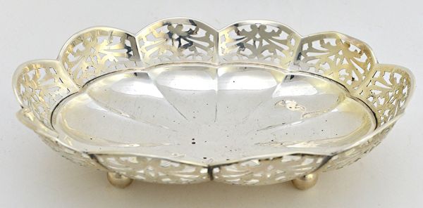 A silver shaped oval shallow bowl, decorated with a pierced border and raised on four spherical feet, Birmingham 1922, width 27cm, weight 340 gms.  Il