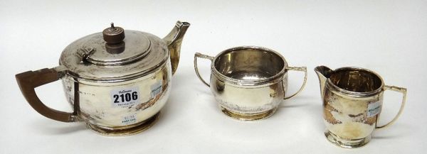 A silver three piece tea set, comprising; a teapot and a twin handled sugar bowl, Birmingham 1937 and a milk jug, Birmingham 1936, the teapot with woo