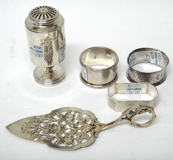 A George III silver pepperette, of cylindrical form, London 1811, three silver napkin rings and a foreign serving trowel, with cast and pierced floral