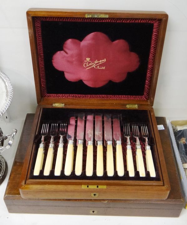 A set of twelve pairs of dessert or fruit knives and forks, with plated blades and prongs, with ivory handles, with a wooden case and a set of twelve