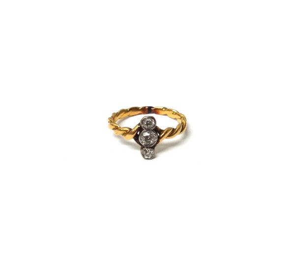 A gold and diamond set three stone ring, mounted with cushion shaped diamonds, in an over and under design, the shank of ropetwist form, with a case.