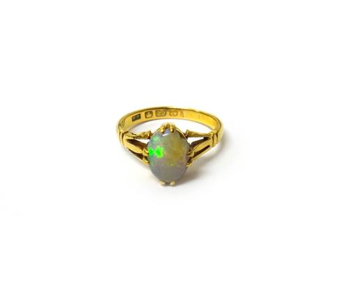 A gold ring, claw set with an oval opal between pierced shoulders, ring size O, with a case.