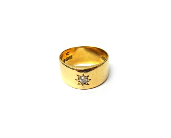 An 18ct gold and diamond set wide band ring, star gypsy set with a cushion shaped diamond, London 1916, ring size Q, gross weight 8.5 gms, with a case