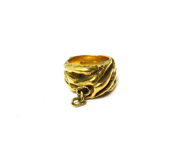 A gold ring, cast in an abstract design, with a partly textured finish, detailed Pomus KT 18, ring size H and a half, weight 18.2 gms, with a case.