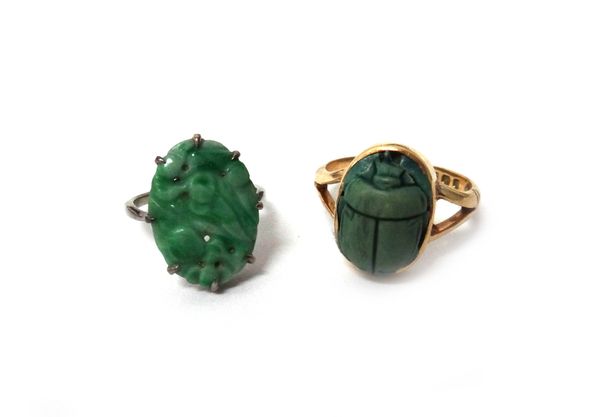 An 18ct gold ring, mounted with a faience scarab, London 1926, ring size Q and a half and a white gold ring, claw set with a carved and pierced oval j