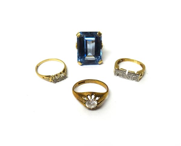 A 9ct gold ring, claw set with a large rectangular step cut blue stone, a 9ct gold and diamond set three stone ring and two further gold and colourles