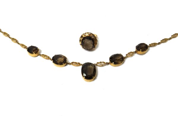 A gold and smoky quartz necklace, the front mounted with a row of five graduated oval cut smoky quartz, otherwise in a scroll pierced link design, on