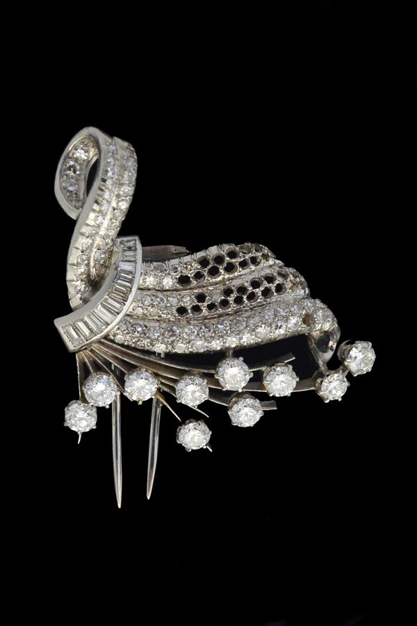 A diamond brooch, in a scrolling and fanned design, claw set with ten principal circular cut diamonds and further mounted with baguette and small circ