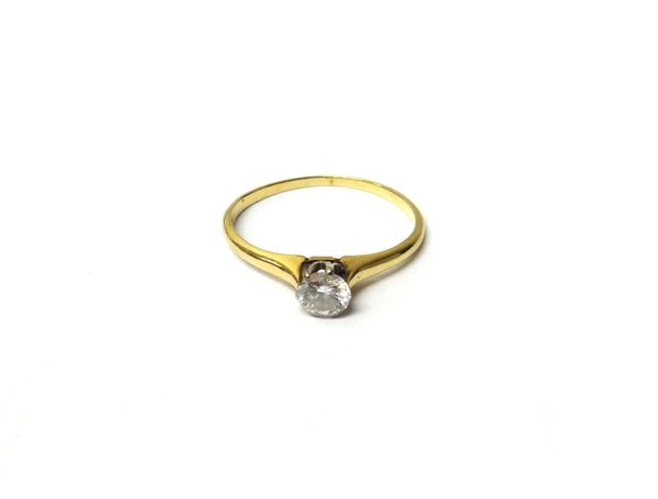 A gold and diamond single stone ring, claw set with a circular cut diamond, detailed 14 K, ring size L and a half.