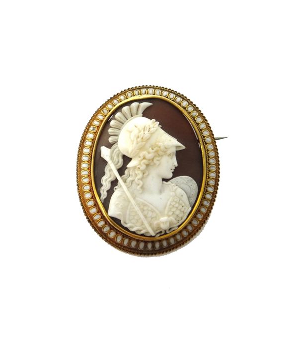 A Victorian gold and white enamel mounted oval shell cameo brooch, carved as Pallas Athene (Goddess of wisdom), decorated with a white enamelled borde