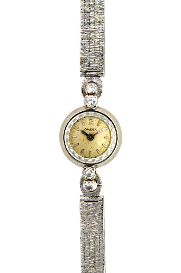 A lady's white gold and diamond set circular cased rear winding Omega dress wristwatch, the signed circular dial with baton shaped numerals, the case