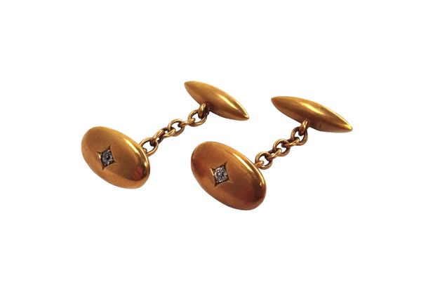 A pair of gold and diamond set cufflinks, each with an oval front, centred by a cushion shaped diamond and with a torpedo shaped back, detailed 18, gr