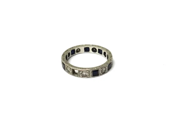 A platinum, diamond and sapphire set full eternity ring, mounted with circular cut diamonds, alternating with square cut sapphires (one sapphire lacki
