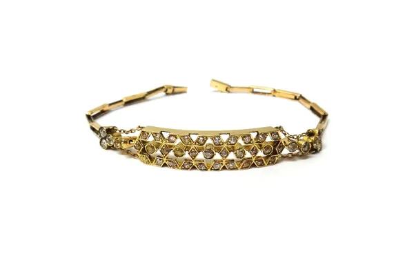 A gold and diamond set bracelet, the front in a curved panel shaped pierced geometric design, mounted with cushion shaped diamonds, otherwise in a bar