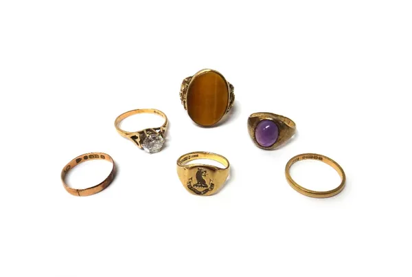 A 9ct gold ring, mounted with an oval tiger's eye, a 9ct gold ring, mounted with an oval cabochon amethyst, a 9ct gold and colourless gem set solitair