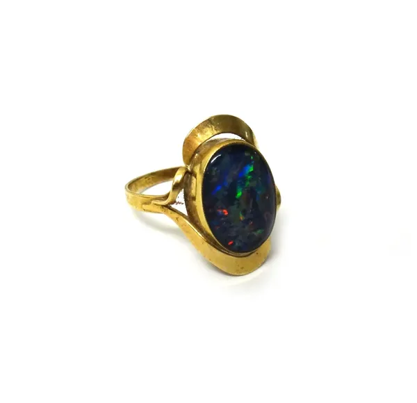A gold ring, mounted with an oval opal doublet, between openwork shoulders, ring size R and a half.