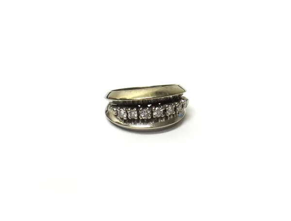 A white gold and diamond set ring, mounted with a row of seven circular cut diamonds between beaded sides, detailed 14 K, ring size M and a half.
