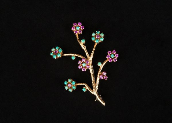 A 18ct gold, ruby and turquoise set brooch, designed as a floral spray.  Illustrated
