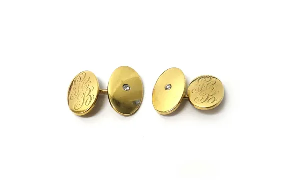 A pair of gold and diamond set cufflinks, with oval backs and fronts, the centre to one side mounted with a cushion shaped diamond and the other sides