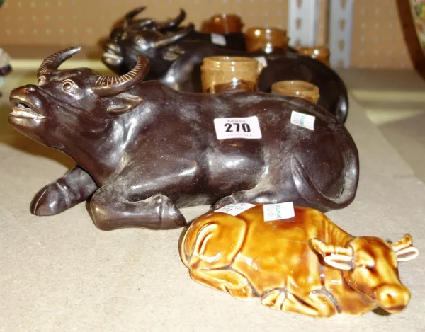 A group of three Oriental ceramic spill vases formed as an ox and a brown glazed figure of a recumbent lion. (4)  S1T