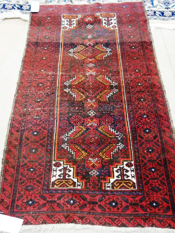 A Belouch rug, with three stepped medallions and geometric design in red, black, white and yellow.  I7