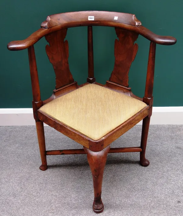 A mid-18th century walnut corner chair, with double vase back, on club supports.