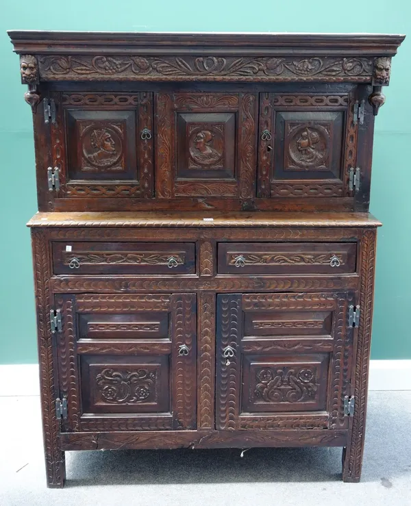 A carved oak court cupboard, 17th century and later, with pair of upper panel cupboards over two drawers and further lower cupboards, on stile feet, 1