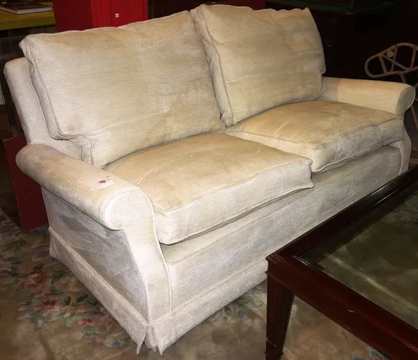A 20th century cream upholstered two seat sofa.  DIS