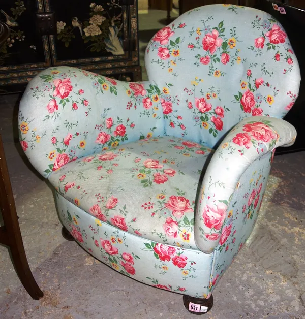 An early 20th century shaped armchair with rose print upholstery.   F6