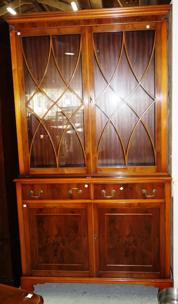 A 20th century yew glazed bookcase cabinet over pair of cupboard doors and a yew bedside cabinet. (2)  I7
