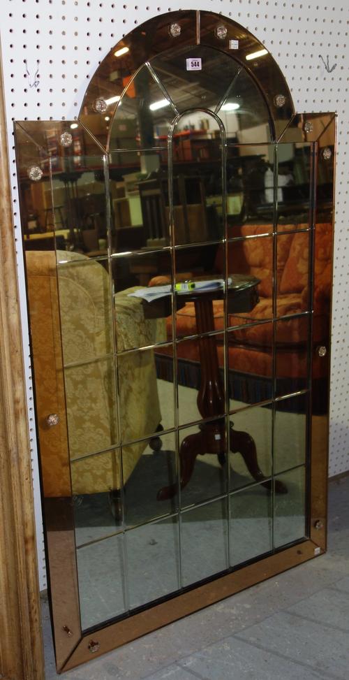A mid-20th century arch top copper and plain glass wall mirror, with geometric bevelled decoration, 80cm wide x 136cm high.  A1