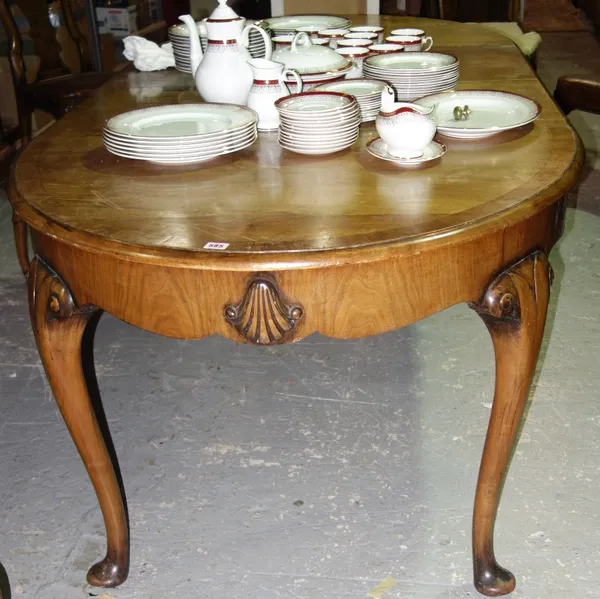 A 20th century oval walnut extending dining table.  GAL