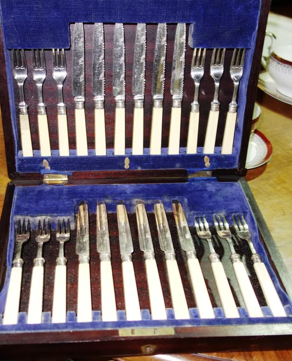 A set of twelve pairs of silver coloured fruit knives with ivory handles, Sheffield 1915, cased, together with a plated three piece condiment set and