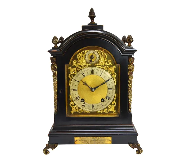 A German eight day ebonised mantel clock, late 19th century, the arch top case with foliate finials, the dial plate with subsidiary slow/fast dial ove
