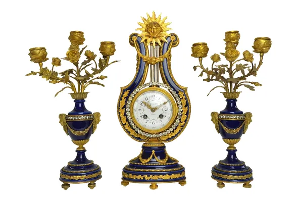 A Louis XVI style blue porcelain and ormolu mounted clock garniture, c.1900, of lyre form, the foliate painted enamel dial detailed 'Tiffany & Co', wi