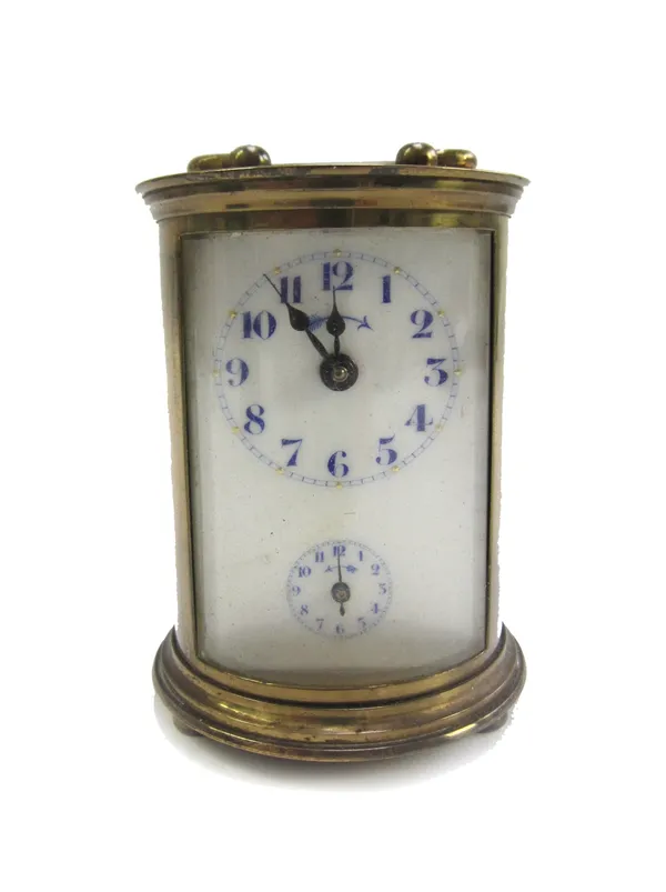 A gilt brass cased carriage clock of cylindrical form, early 20th century, the white enamel dial with subsidiary alarm, key to base and leather cylind