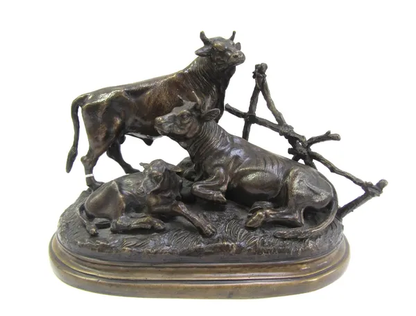 After Moigniez, a patinated French bronze cow group, 20th century, depicting a bull, cow and calf atop a naturalistic oval shaped base, signed 'J. Moi