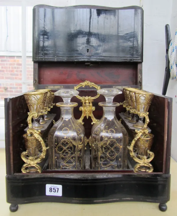 A rosewood and inlaid ebonised table top liquor case, 19th century, with serpentine front, the hinged lid and sides opening to reveal a Continental gi