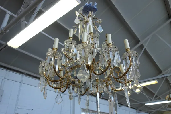 A Louis XV style eighteen branch brass and cut glass chandelier, the baluster stem issuing eighteen branches over two graduated tiers hung with shaped