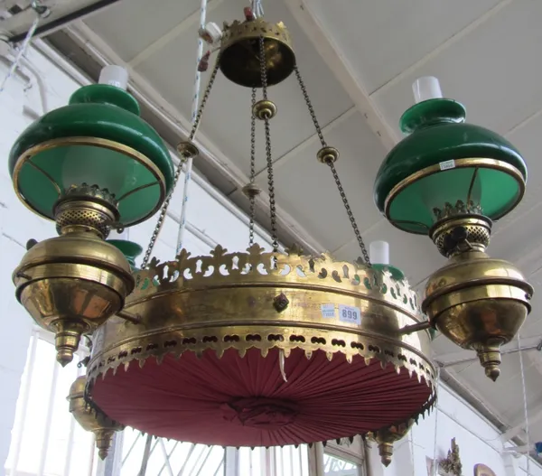 A Victorian circular brass hanging light, in the Gothic taste, suspended on four knopped suspension chains and the four green glass oil lamps on a pie