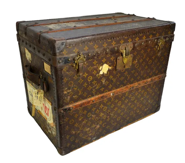 A Louis Vuitton trunk, early 20th century, with wooden and metal banding over a LV gilt brown canvas, stamped brass hardware, the interior with paper