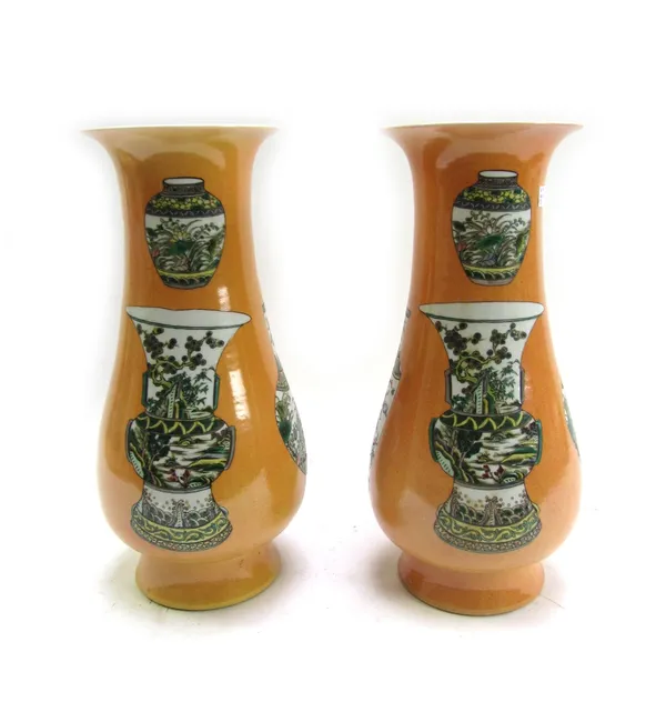 A pair of modern Chinese porcelain vases, decorated with further Wucai vases against a powdered orange ground, six character mark to base, 41cm high (